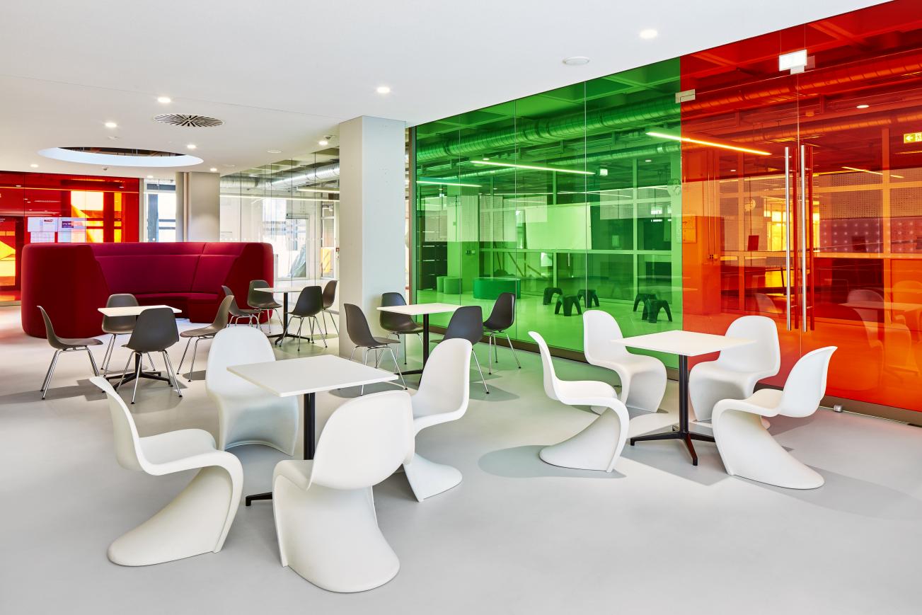 Innenaufnahme: Moderne Cafeteria mit rechteckigen Bistro Tischen und Stühlen von Vitra.