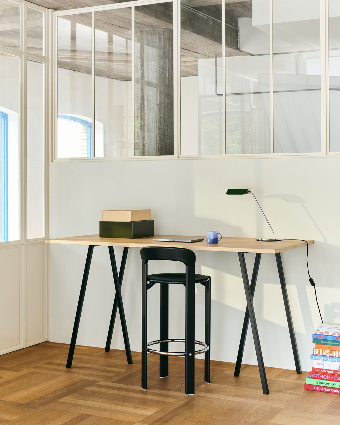 Schwarzer Rey Barhocker von Hay vor Schreibtisch in modernem Büro. Design Barstuhl mit Fußstütze.