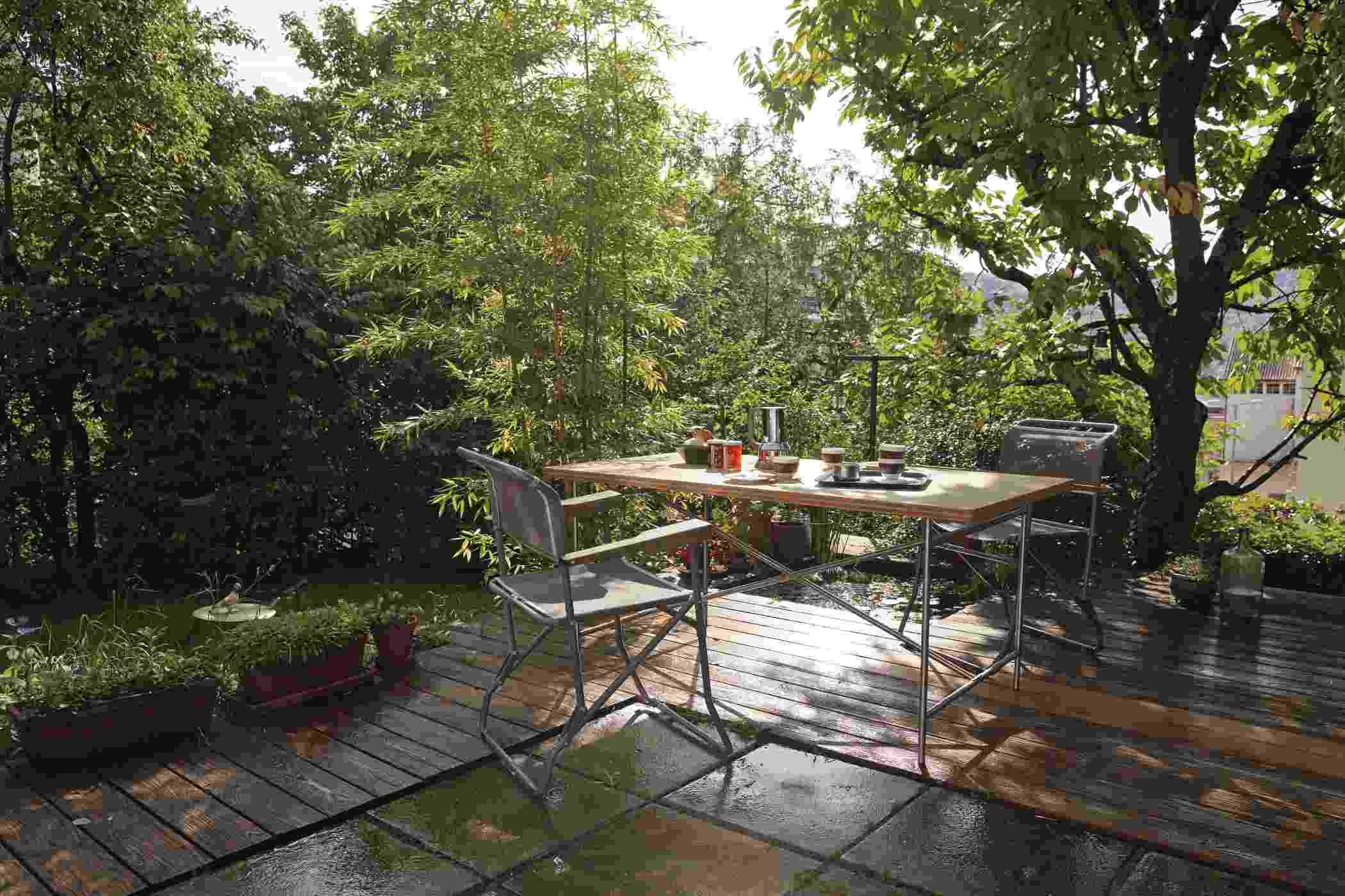 Eiermann Tisch mit Stühlen auf einer Terrasse im Grünen. Outdoor Esstisch für Garten.