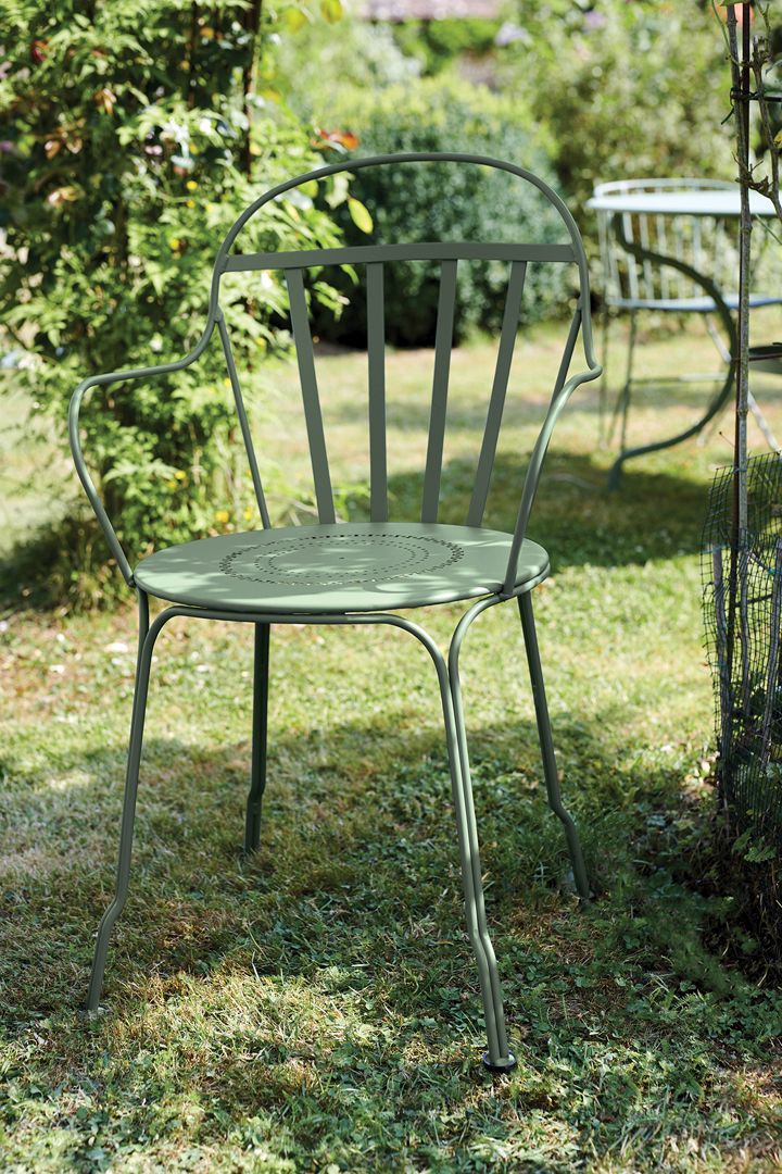 Grüner Louvre Stuhl von Fermob im Garten. Metallstuhl für den Außenbereich mit Armlehnen.