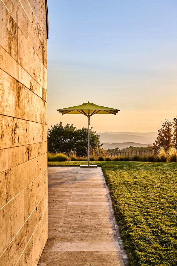 Weishäupl Trend Schirm: Grüner Sonnenschirm im Garten mit Blick auf die Landschaft bei Sonnenuntergang.