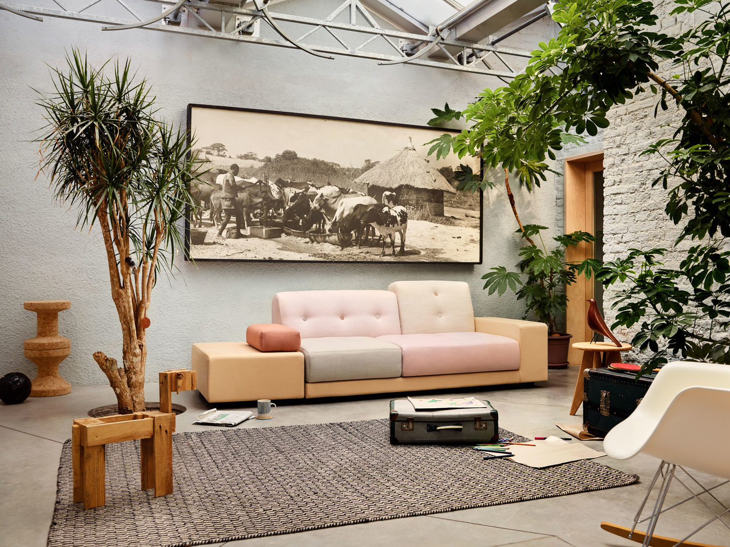 Heller Raum mit Sofa, Teppich und einem weißen Eames Plastic Arm Rocking Chair (RAR) Schaukelstuhl.