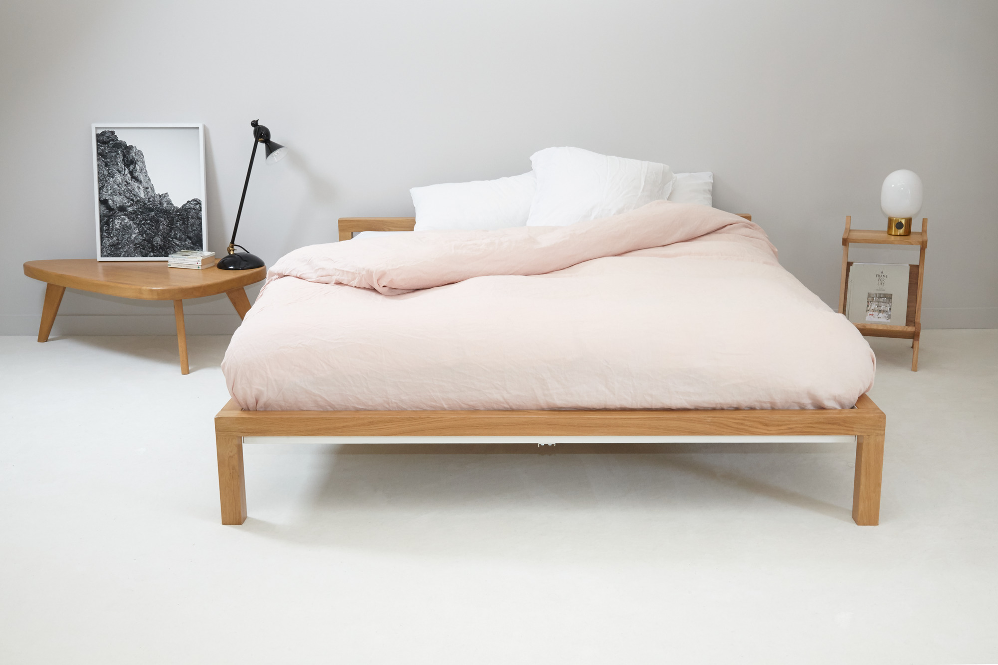 Hans Hansen Bett Eiche 180x200 cm mit Bettwäsche und Nachttischen im Schlafzimmer.