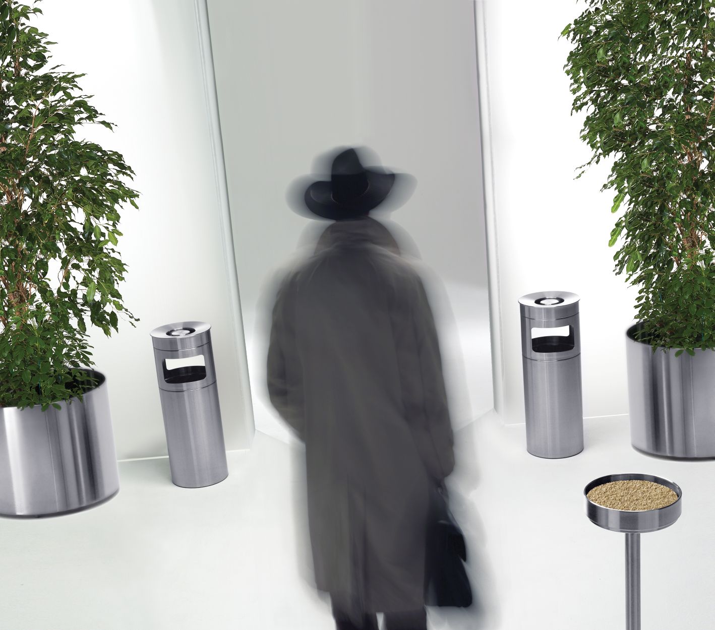 Nox Standascher und Rexite Papierkorb aus Edelstahl in modernem Büroambiente mit Pflanzen.