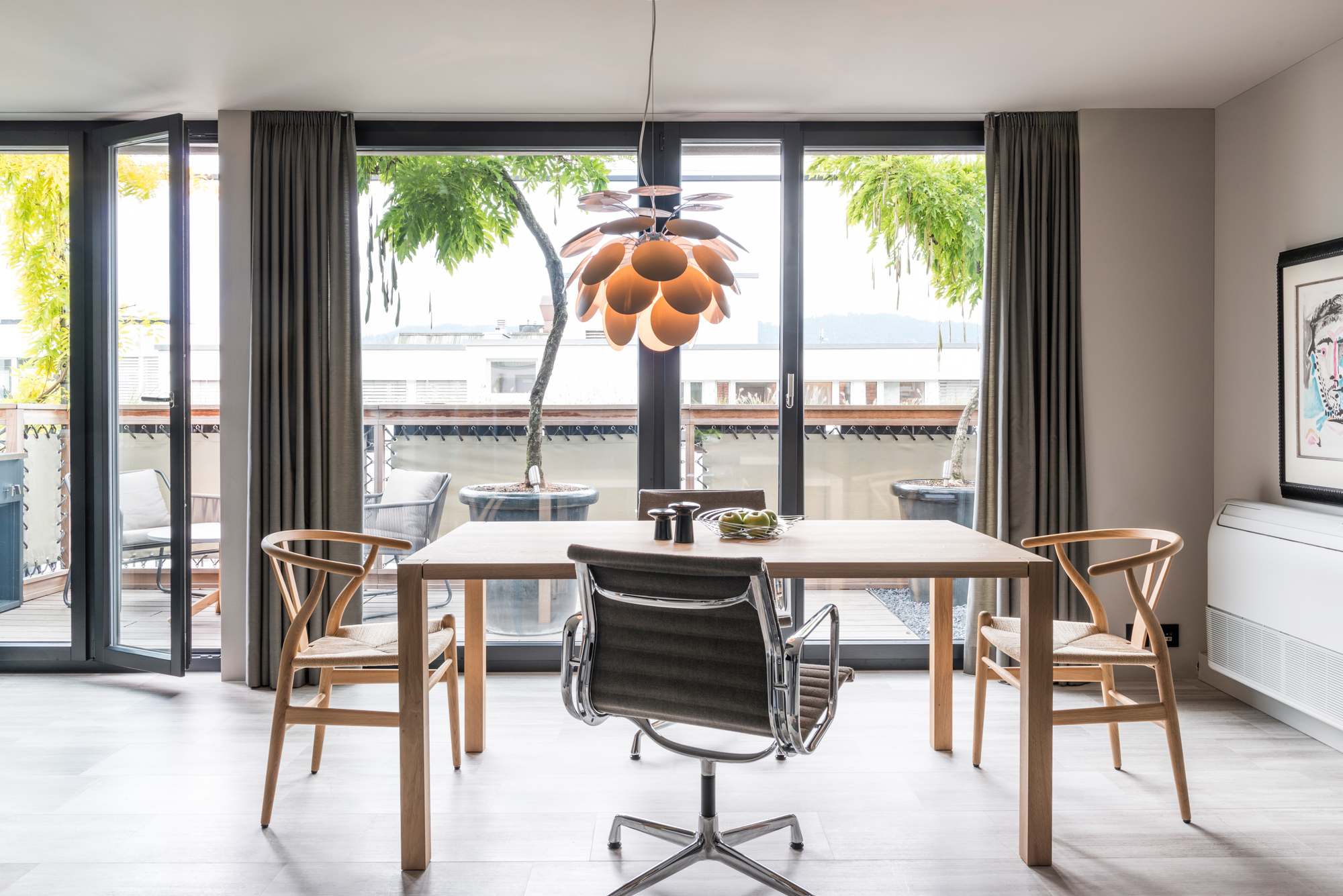 Discocó Pendelleuchte in Schwarz-Gold über Esstisch. Marset Designleuchte für stilvolle Beleuchtung im Esszimmer.