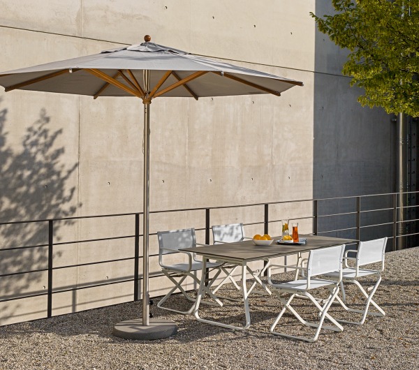 Weishäupl Trend Sonnenschirm über einer Gartentischgruppe mit weißen Klappstühlen und Getränken im Freien.