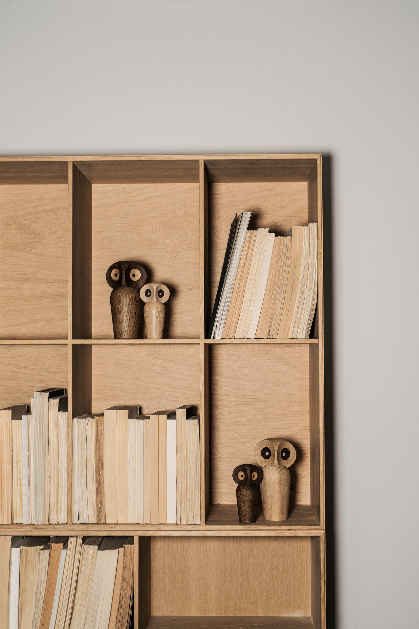 Regal mit Büchern und zwei Architectmade Holzfiguren Eulen, dekorative Holzobjekte.