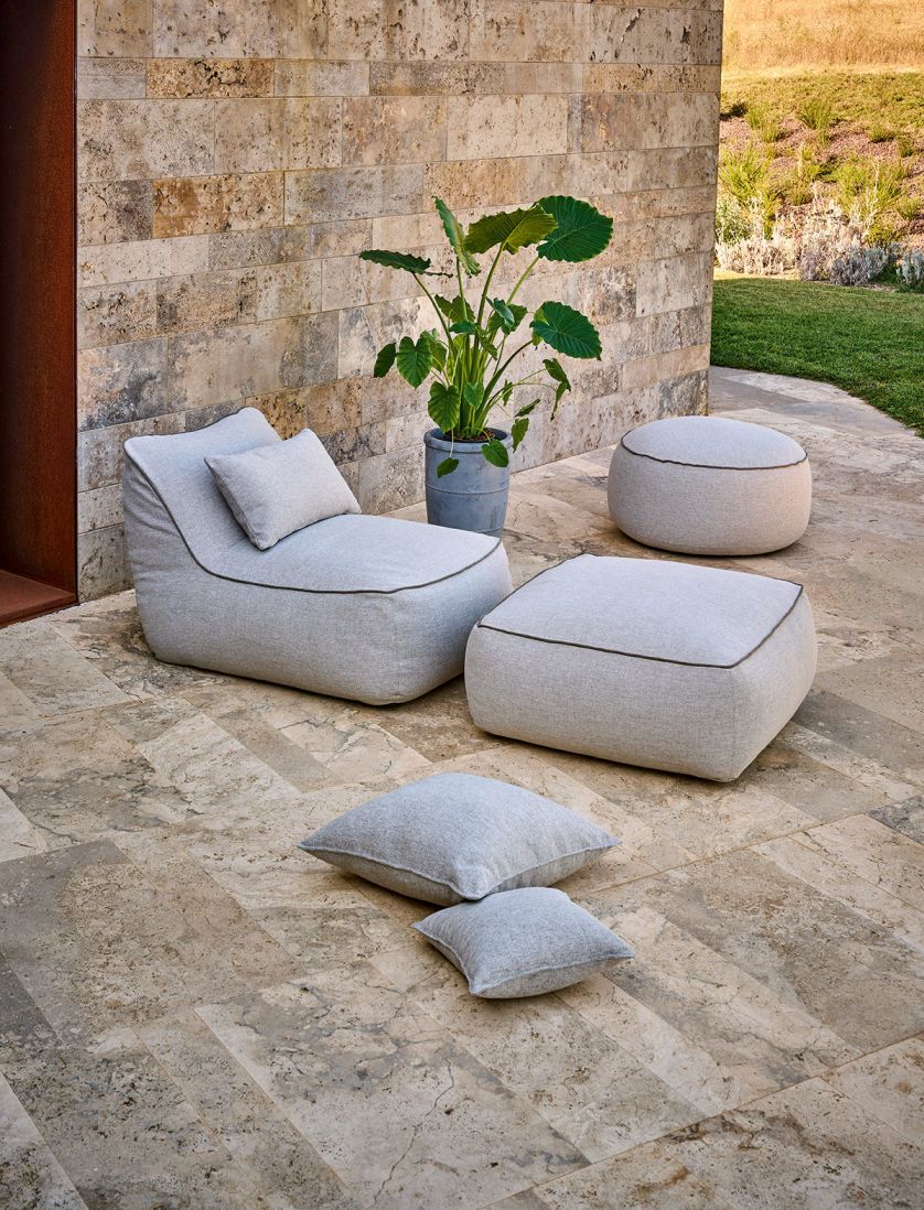 Maliha Lounge Hocker "Pebble" von Weishäupl: Outdoor Sitzmöbel und Kissen in Grau auf Terrasse.