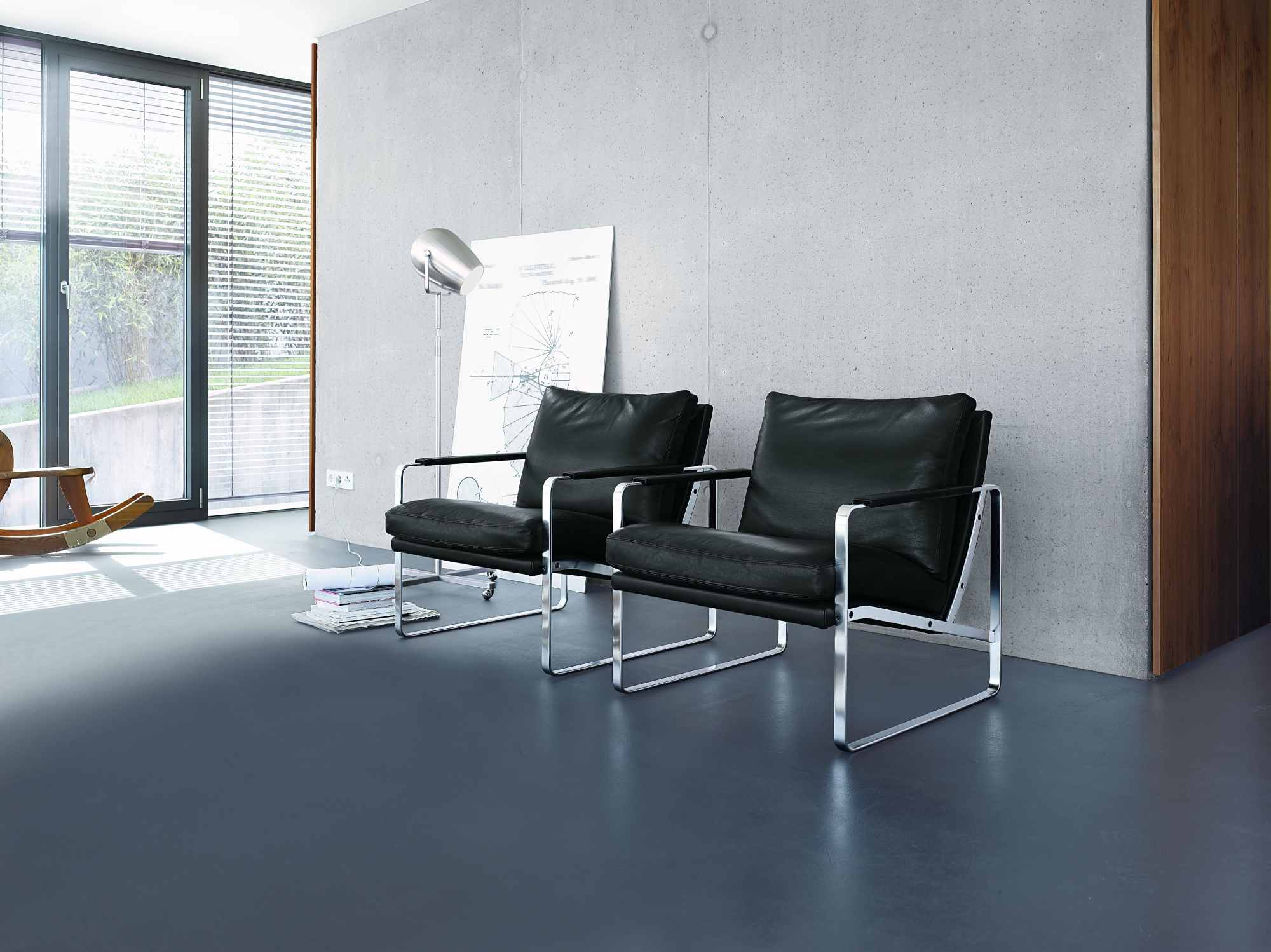 Zwei schwarze 710 Fabricius Sessel von Walter Knoll mit Chromgestell in modernem Ambiente.