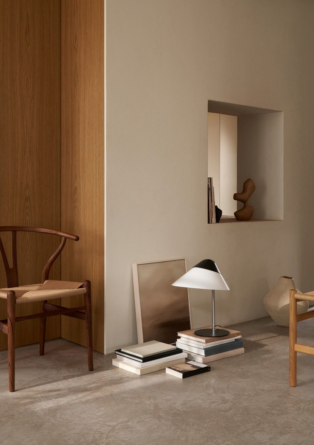 Helle HJW02 Opala Tischleuchte von Carl Hansen & Søn auf Bücherstapel im Interieur.