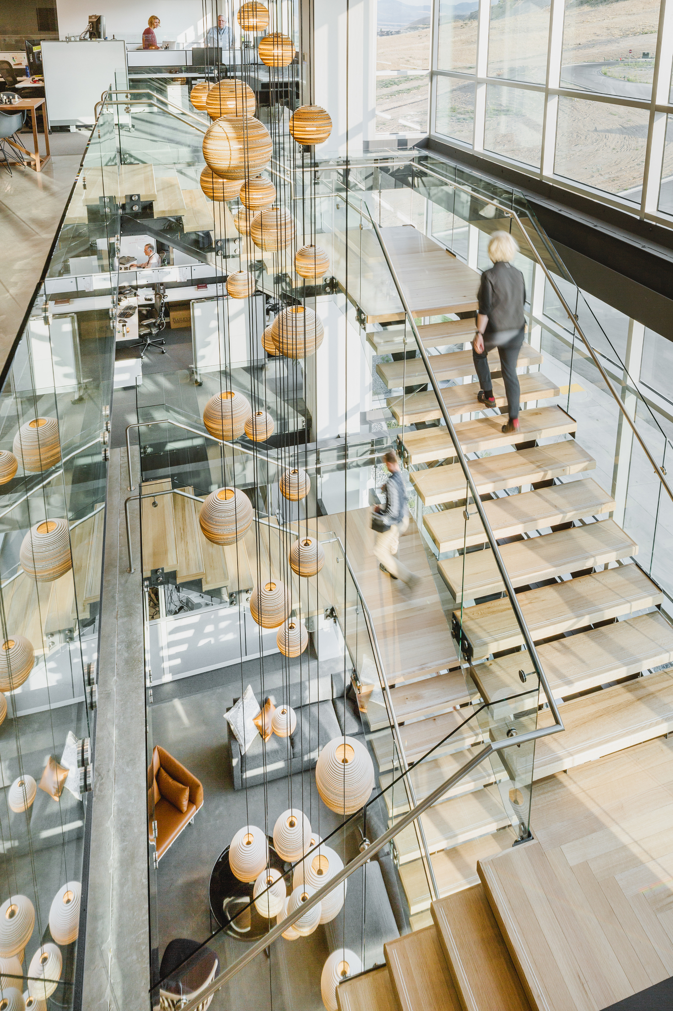 Ansicht von oben: Mehrere Graypants Scraplights Hängeleuchten in einem modernen Bürogebäude.