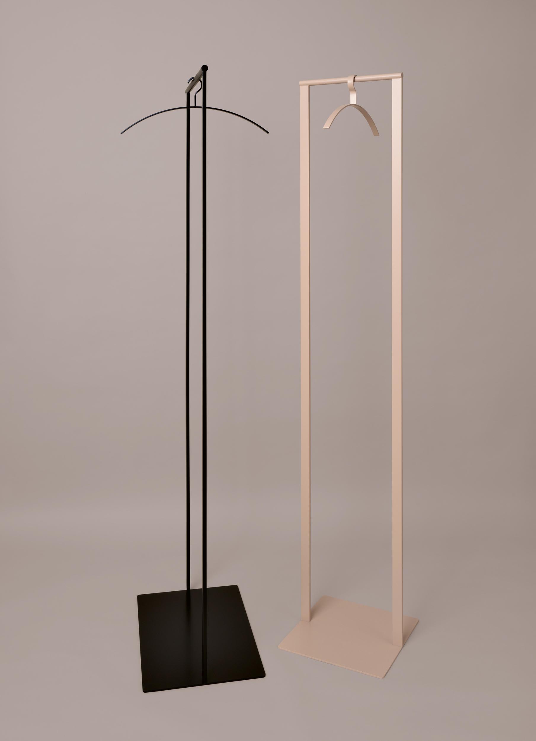 Zwei moderne Schönbuch Garderobenständer: Schwarz mit Bügel, Beige mit Haken, minimalistisches Design.