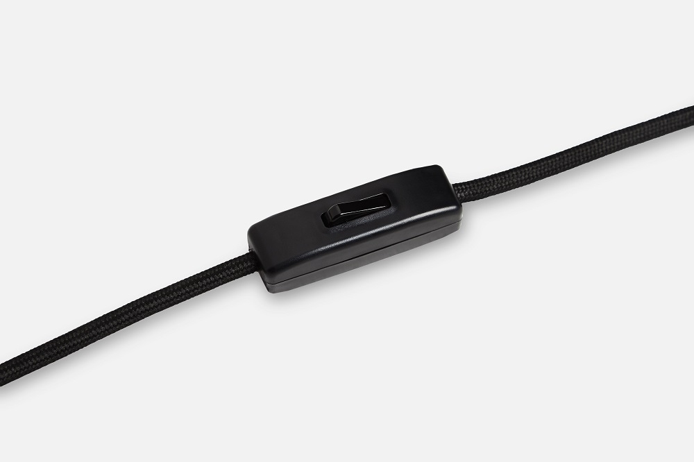 Detailaufnahme des Schalters am Kabel der Woud Cono Tischleuchte, schwarzes Textilkabel.