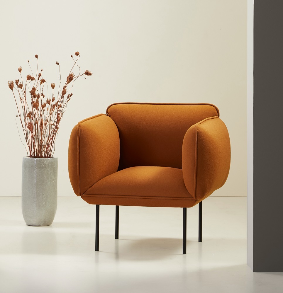 Nakki Sessel von Woud, orangefarbener Polstersessel mit schwarzen Beinen und minimalistischem Design.