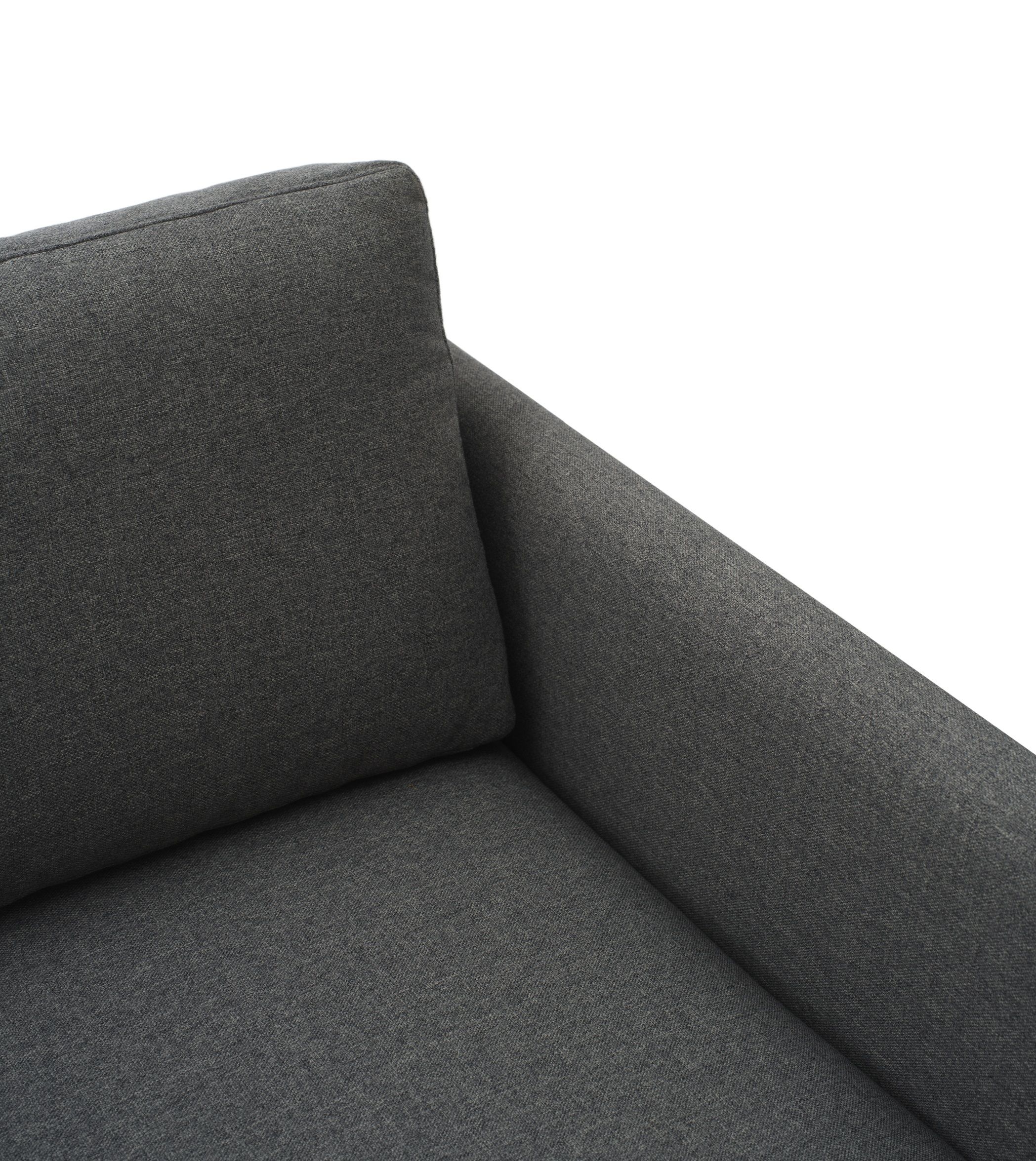 Detailaufnahme des grauen Rar Sofas von Normann Copenhagen mit Armlehne und Kissen.
