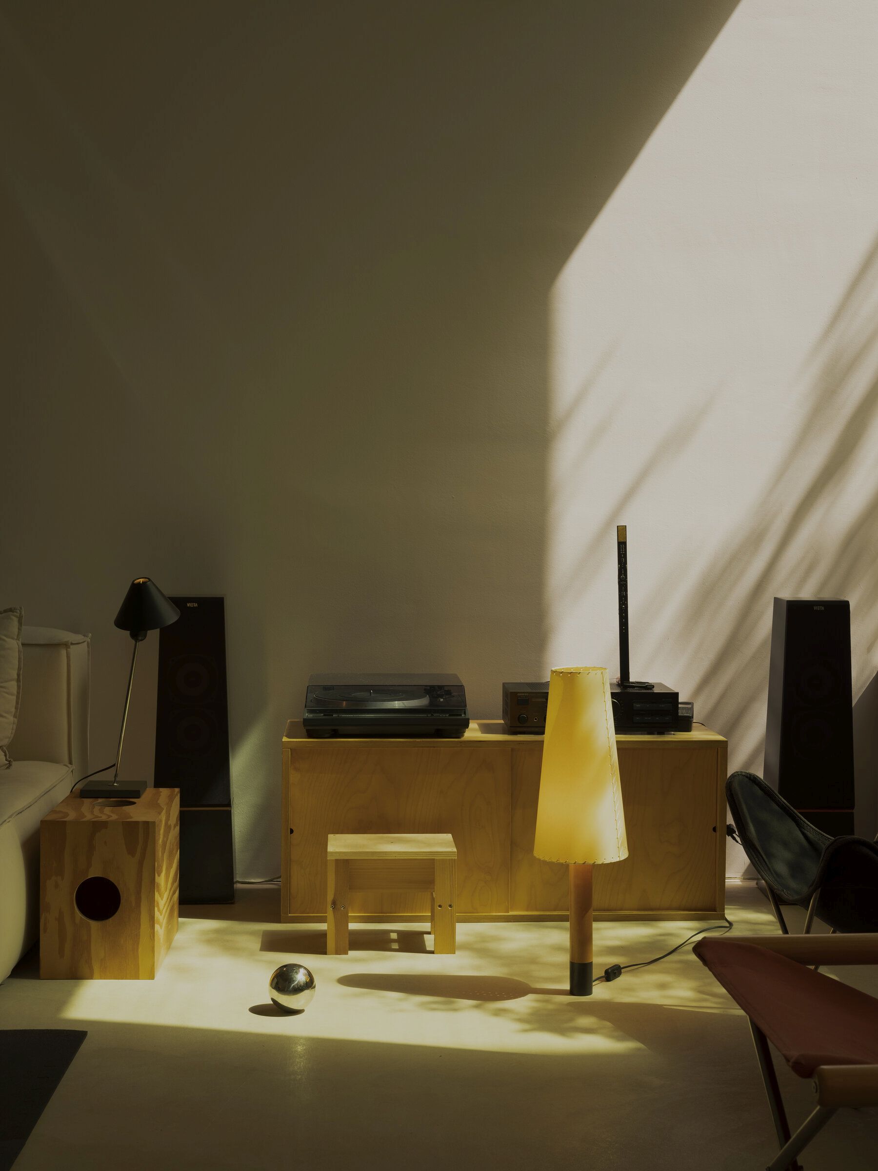 Basica Tischleuchte von Santa & Cole in einem Wohnzimmer mit warmem Licht.