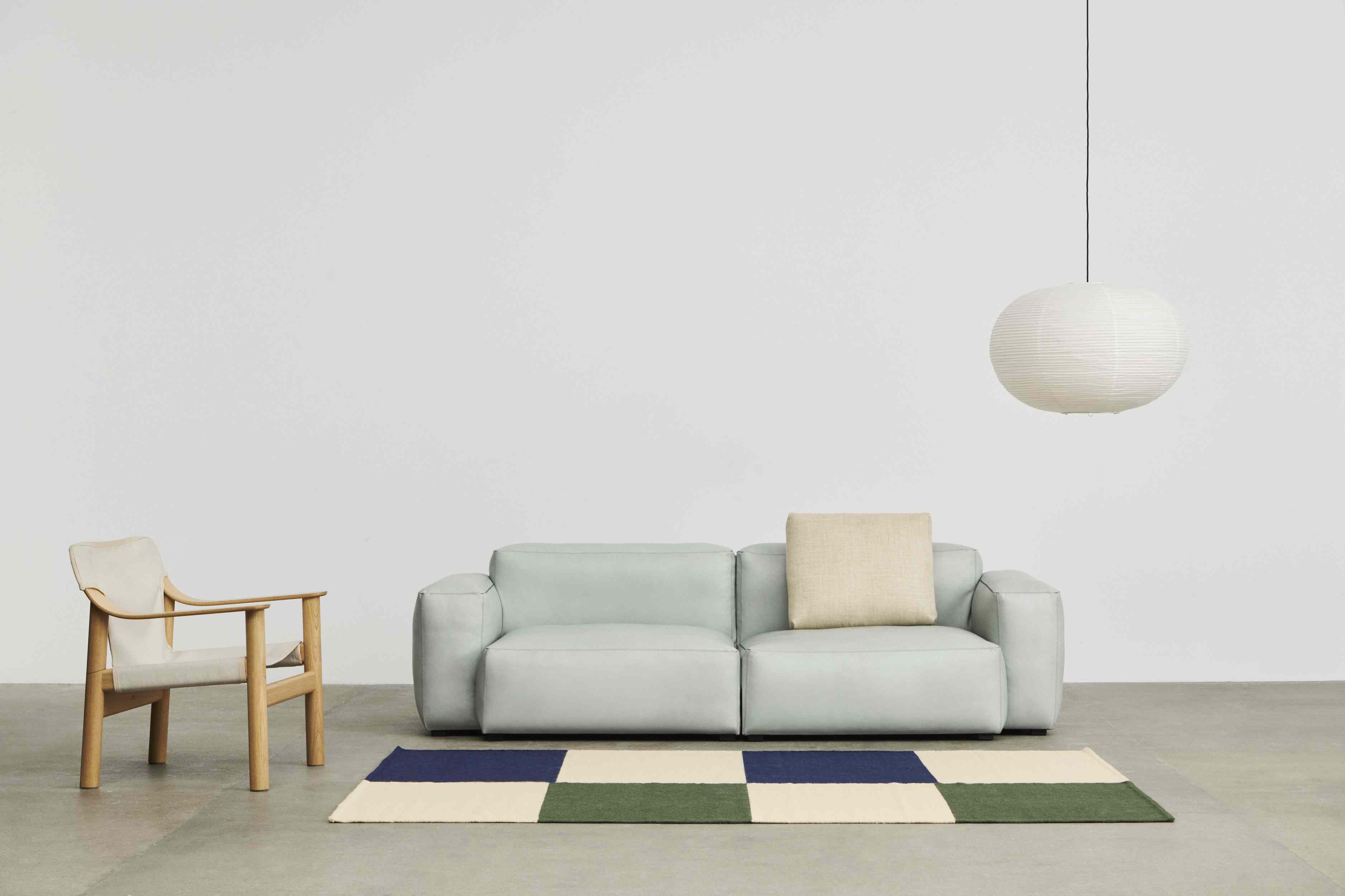 Mags Soft Sofa in hellblauem Linara Stoff mit beigem Kissen und Teppich.