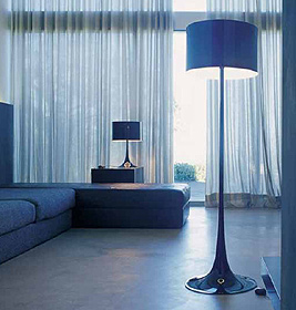 Elegante blaue Stehleuchte "Spun Light" von Flos im modernen Wohnzimmer mit passender Einrichtung.