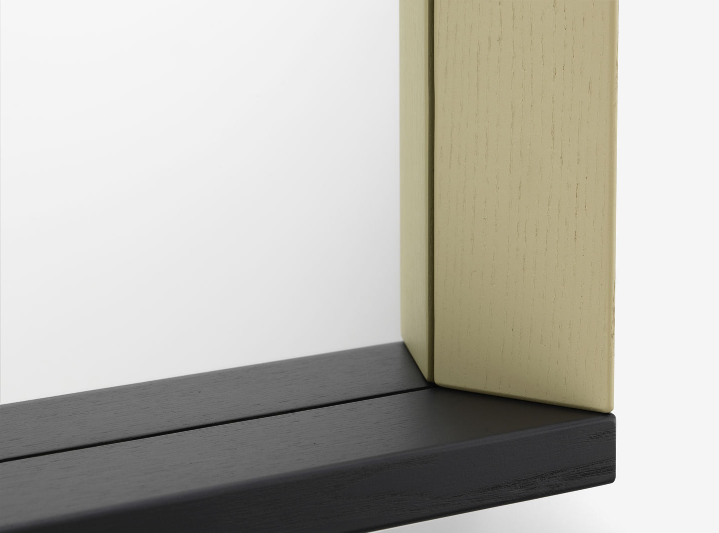 Detailaufnahme eines Colour Frame Spiegels von Vitra mit schwarzem und beigem Holzrahmen.