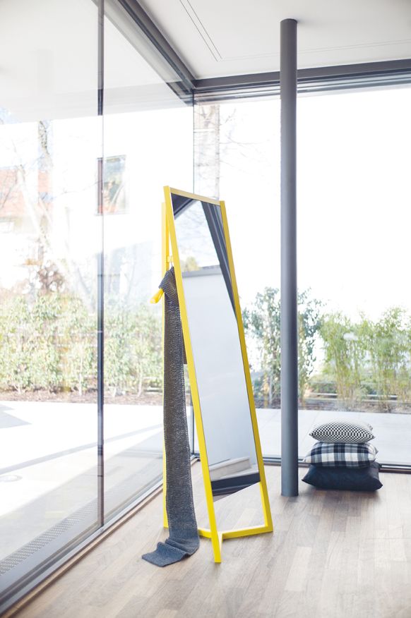 Gelber Schönbuch Standspiegel mit Garderobe und Schal vor Fenster. Moderner, skandinavischer Spiegel für Flur und Schlafzimmer.