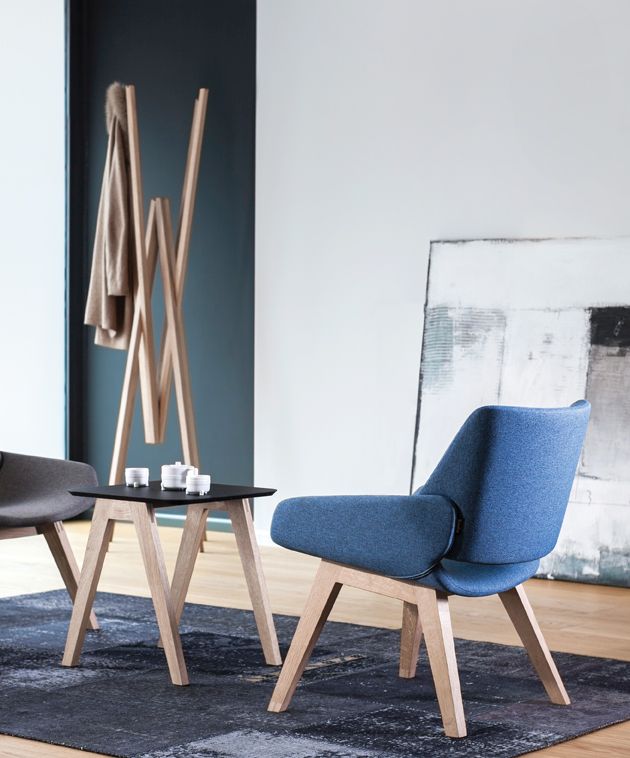 Heller Simetria Kleiderständer von Prostoria aus Holz im modernen Wohnzimmer mit Stühlen und Tisch.