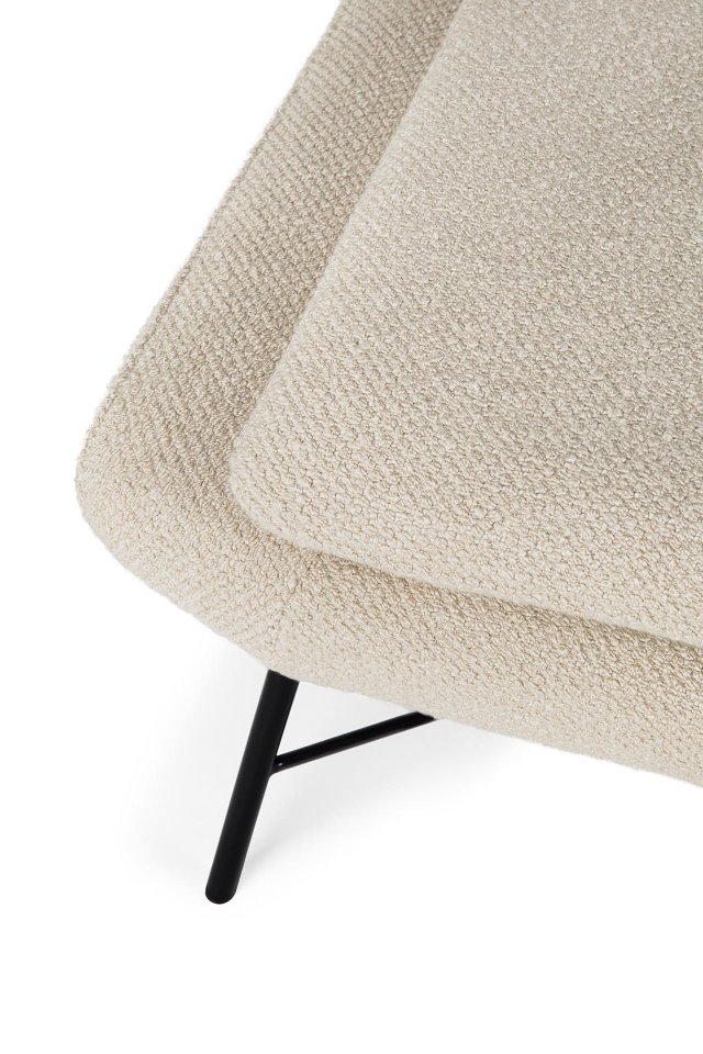 Detailaufnahme des Ethnicraft Barrow Fußhockers mit beigem Bouclé-Bezug und schwarzen Metallbeinen.