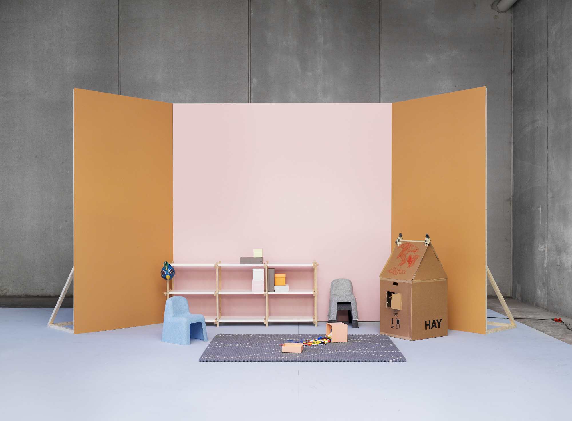 Helles Kinderzimmer mit HAY Woody Low Regal, Spielzeug, Teppich und Kartonhaus.