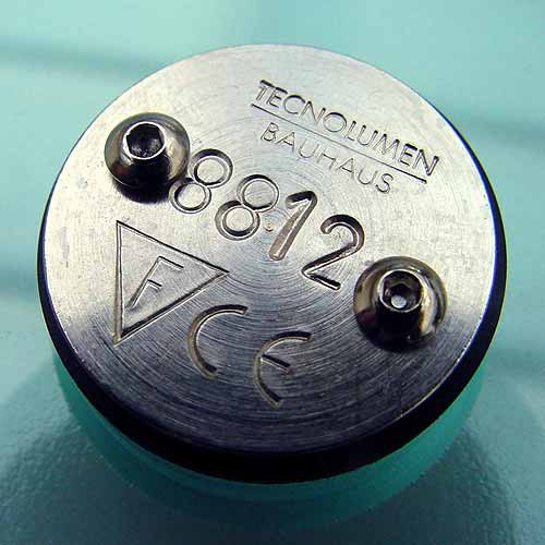 Detailaufnahme des Sockels der WA 23 SW Wagenfeld Tischleuchte von Tecnolumen mit Herstellerlogo und Seriennummer.