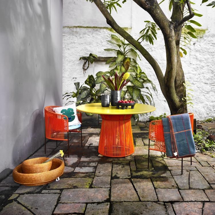 Ames Caribe Lounge Chair in Kaugummirosa, Outdoor Sessel mit passendem Tisch auf Terrasse.