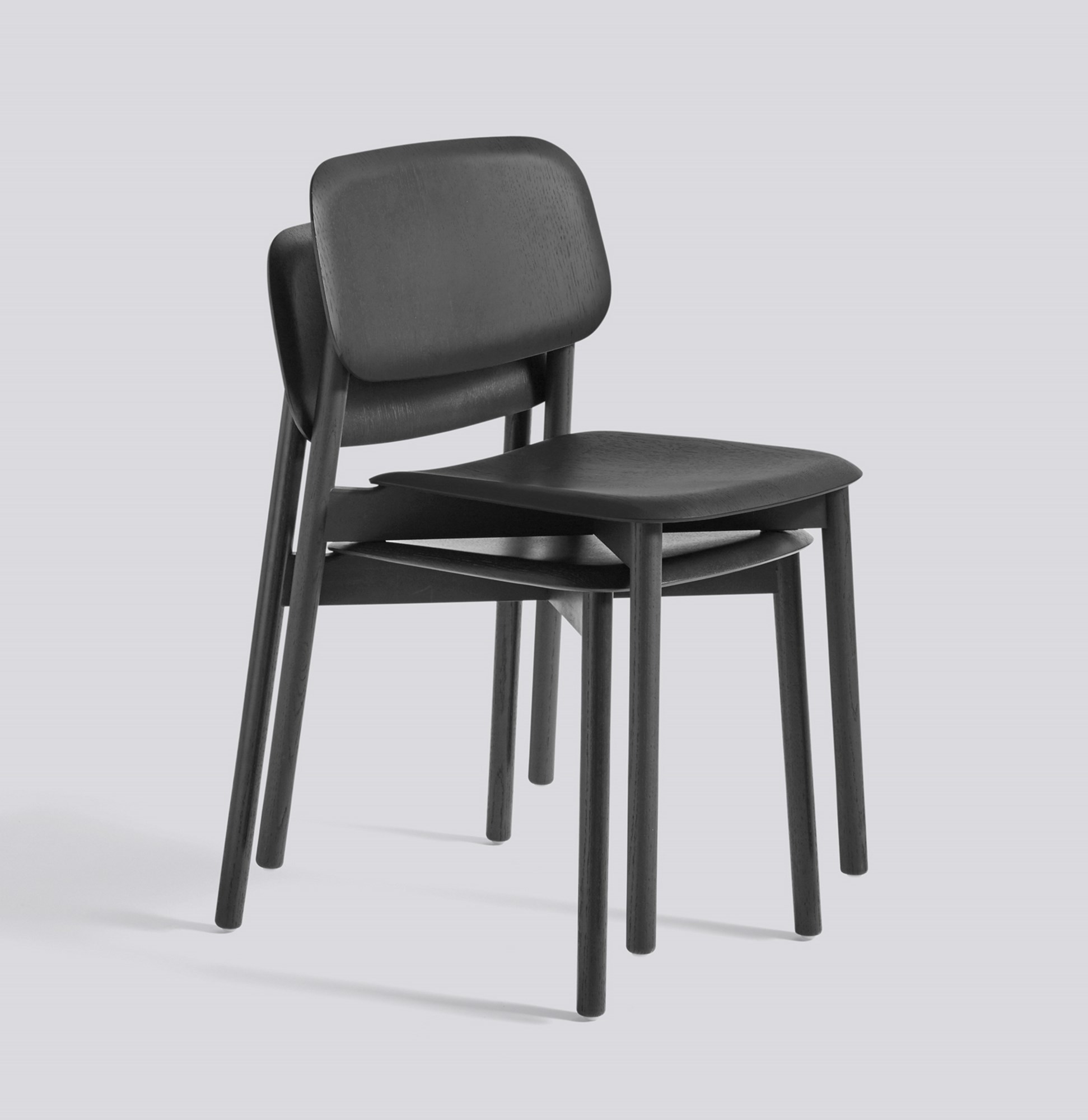 Zwei schwarze Hay Soft Edge 60 Stühle aus Holz gestapelt, modernes Möbeldesign.