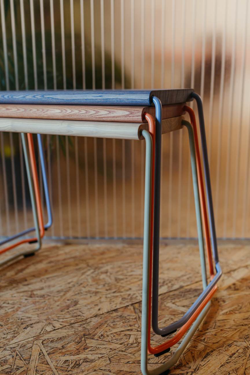 D:003 Beistellhocker von Fuchs & Habicht: Stapelbare Hocker mit farbigen Metallbeinen und Holzplatte.