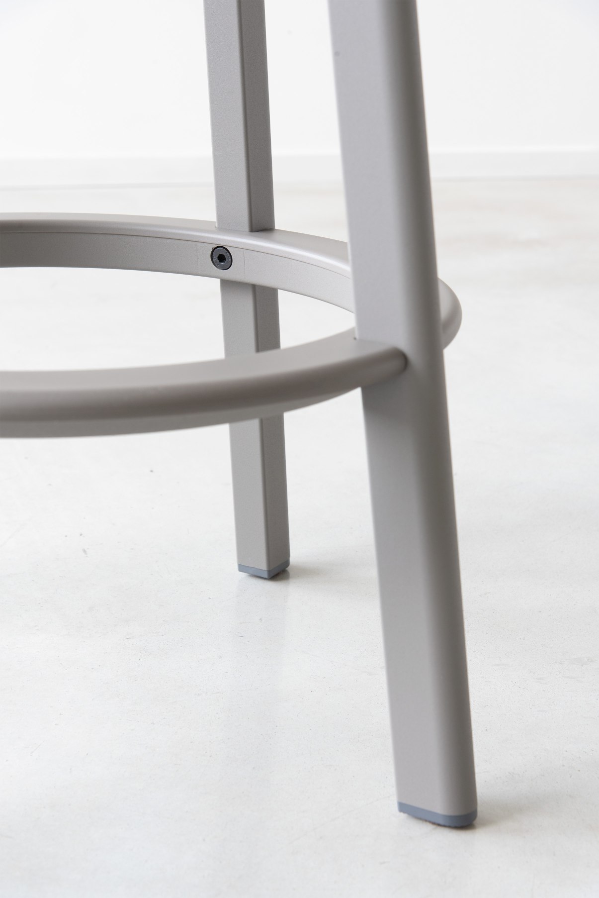Detailaufnahme des grauen Déjà-vu Barhockers von Magis: Beine, Fußstütze und Bodengleiter.
