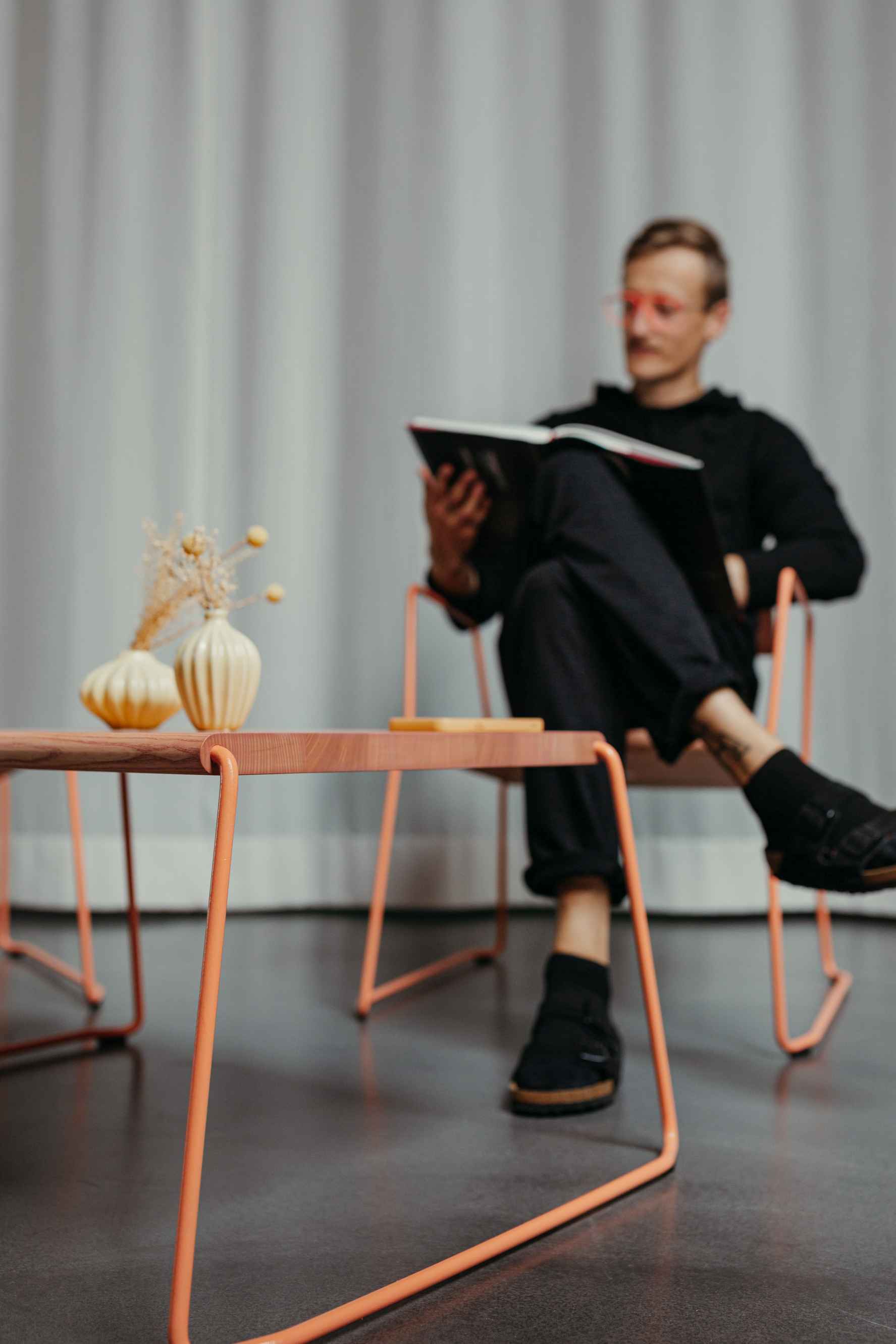 Moderner Couchtisch "Fuchs & Habicht" mit orangefarbenem Gestell und Holzplatte, ideal für Wohnzimmer.