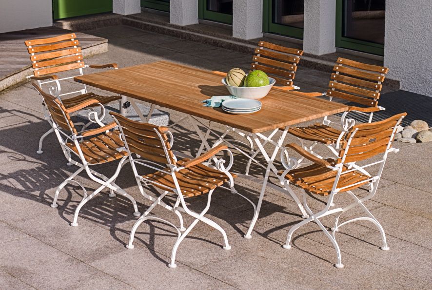 Weishäupl Classic Tisch B 120 cm Outdoor Weiß mit Holzstühlen auf einer Terrasse.