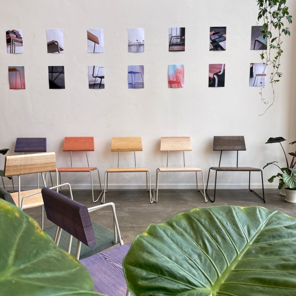 D:007 Loungechair Kohleschwarz Fuchs & Habicht im Raum mit weiteren Stühlen und Pflanzen. Designermöbel.