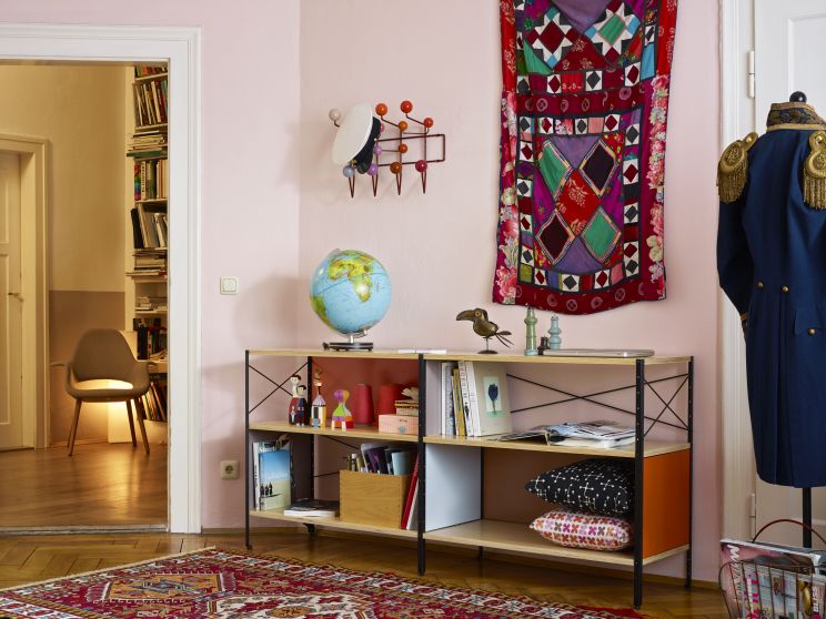 Detailaufnahme der roten Eames Hang it all Garderobe von Vitra an einer rosa Wand. Designklassiker.