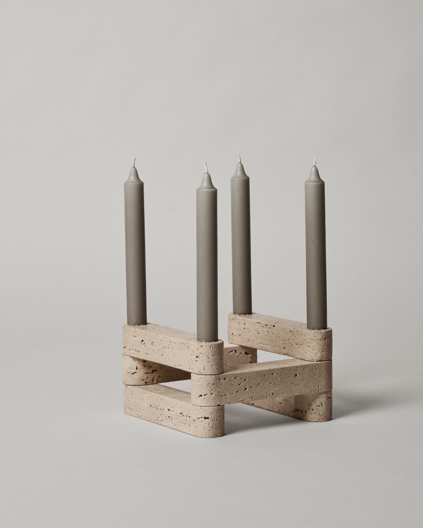 Newel Kerzenhalter von Ferm Living: Modularer Kerzenständer aus Travertin mit vier grauen Kerzen.
