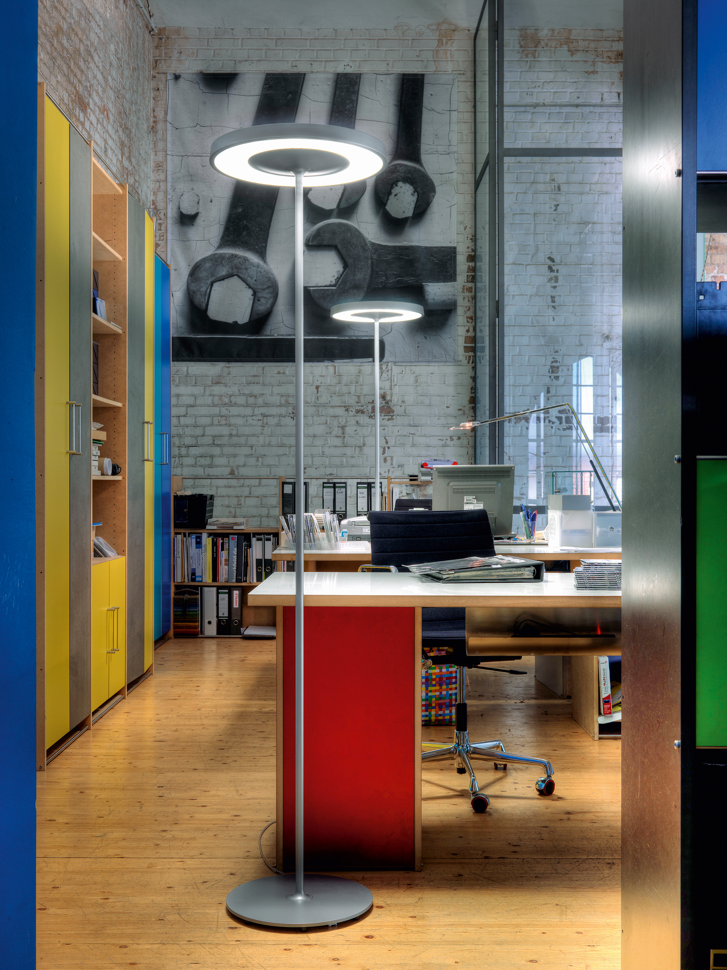 Disk Stehleuchte von Belux im Büro: Moderne LED-Stehlampe mit runder Leuchtfläche.