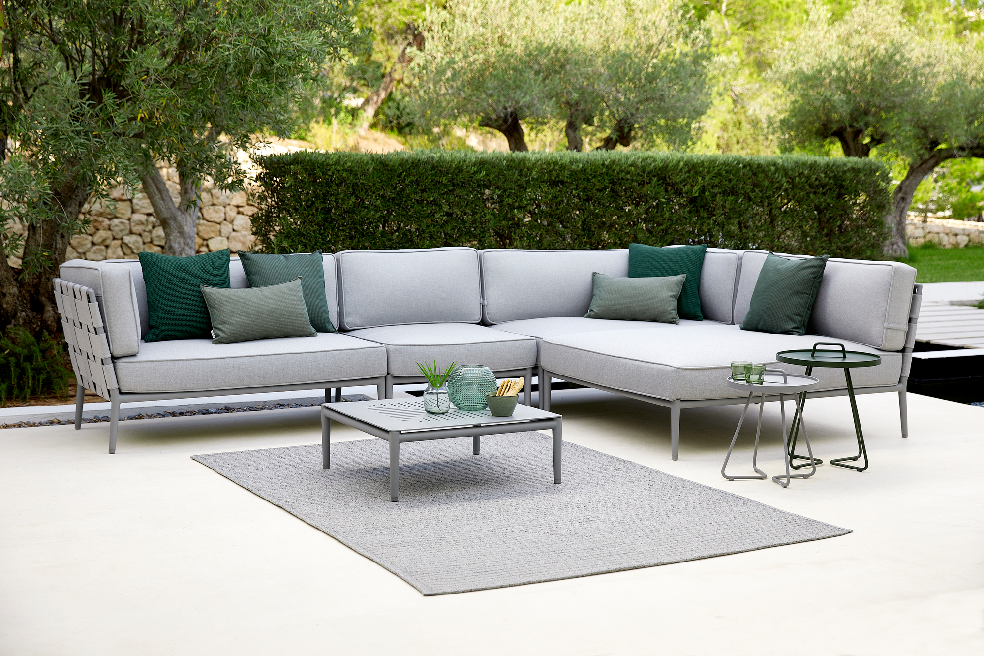 Conic AirTouch Daybed Modul von Cane-Line: Graues Outdoor Sofa mit grünen Kissen.
