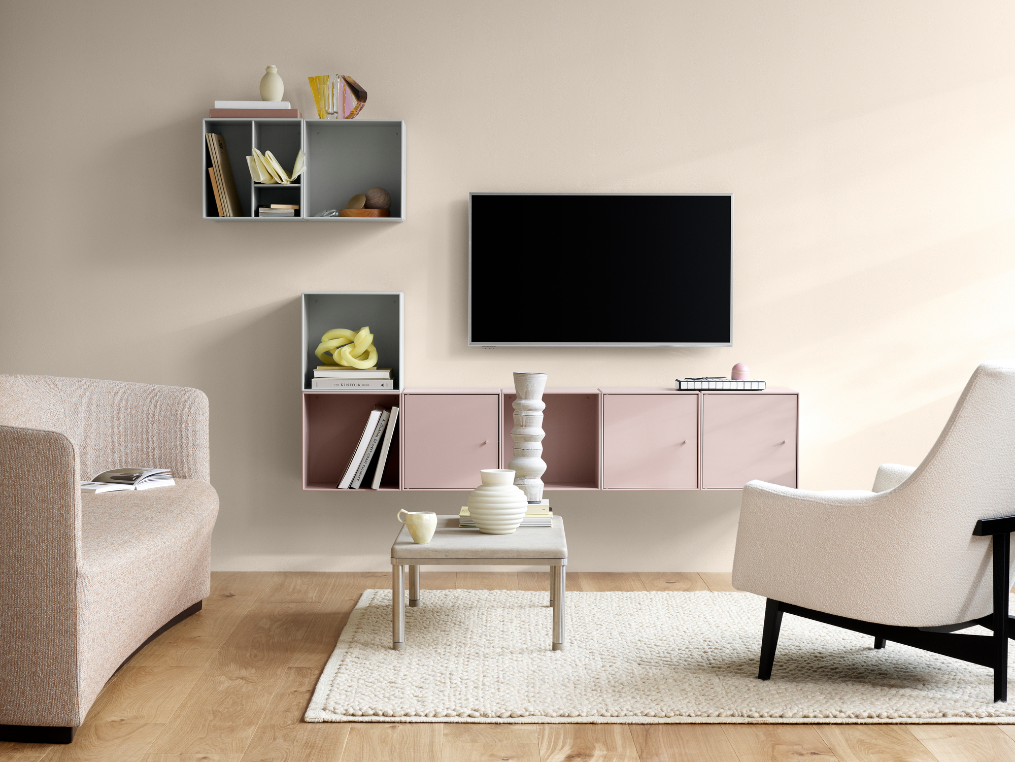 Wohnzimmer mit Montana Mini Modulen in Grau und Rosa, offene Regale zur Wandgestaltung.