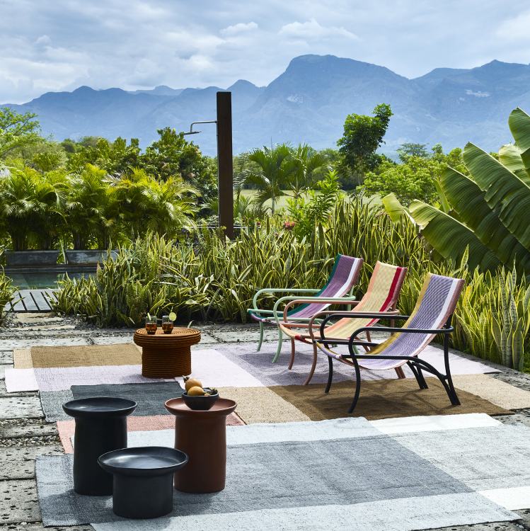 Nobsa Teppich groß: Farbiger Outdoor Teppich mit Stühlen und Tischen vor Berglandschaft.