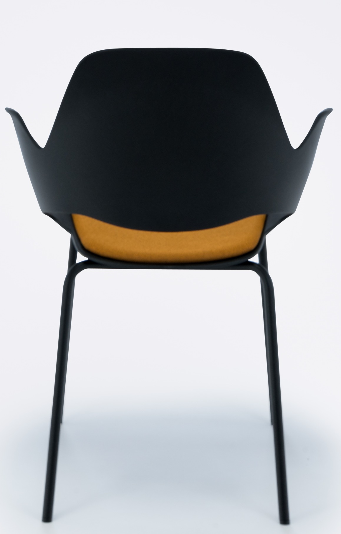 Falk Stuhl von Houe, Ansicht von hinten, schwarze Sitzschale, gelbes Kissen, Metallbeine.