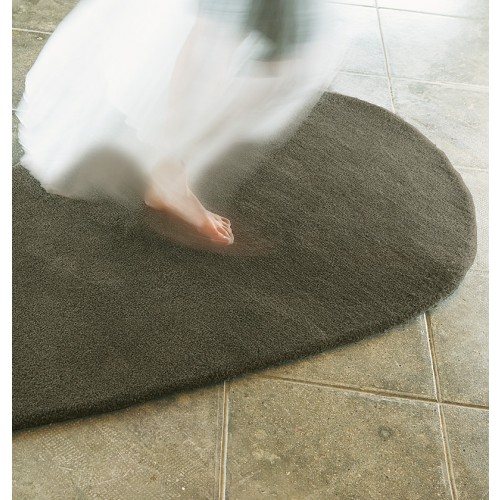 Fuß auf grauem Stone-wool Teppich von Nanimarquina. Hochwertiger Wollteppich für Wohnzimmer und Schlafzimmer.