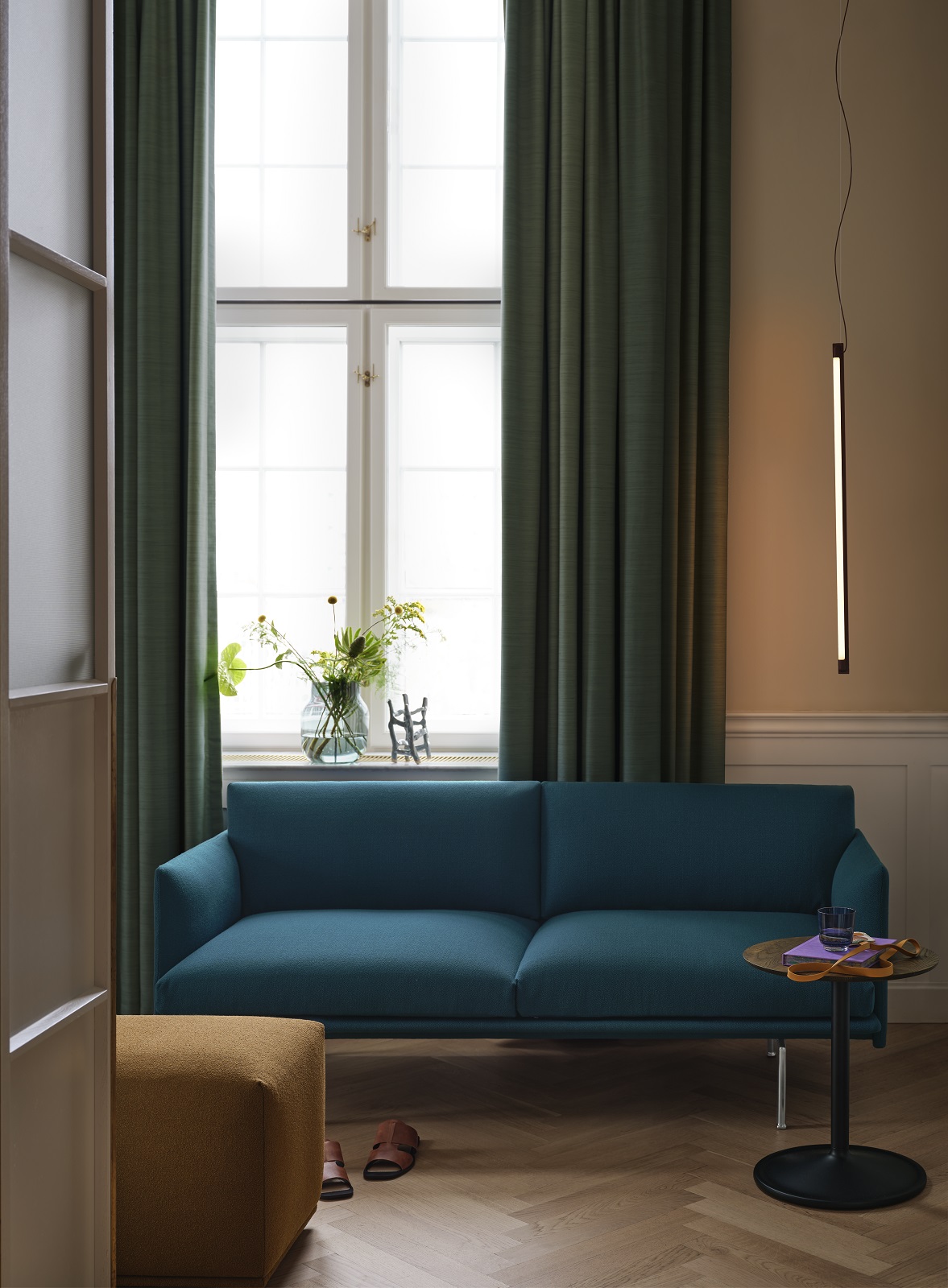 Blaues Muuto Outline Studio Sofa 140 cm im Wohnzimmer mit Beistelltisch und Hocker.