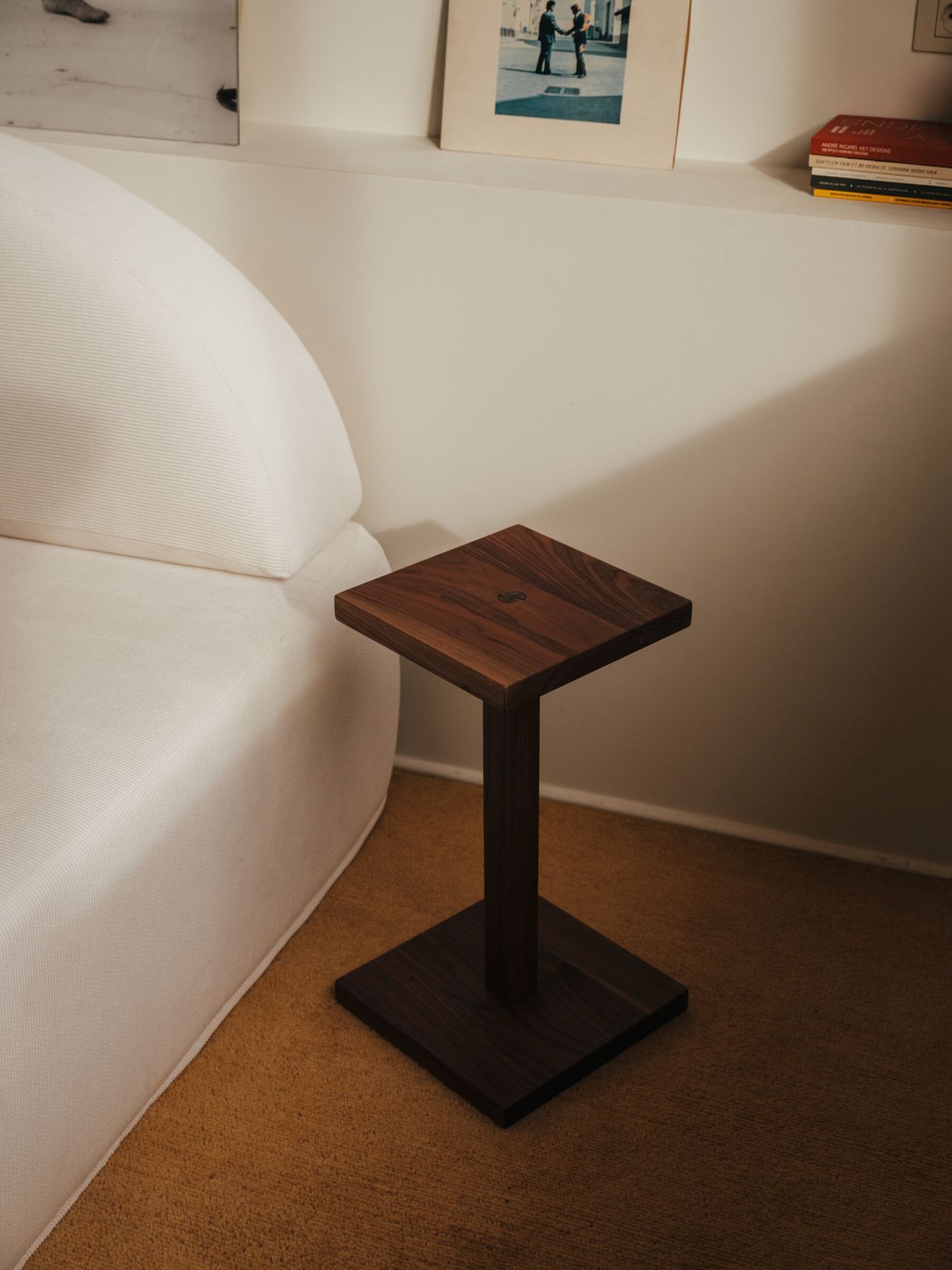 Quadratischer Peana Molina Beistelltisch von Santa & Cole aus dunklem Holz neben einem Sofa.