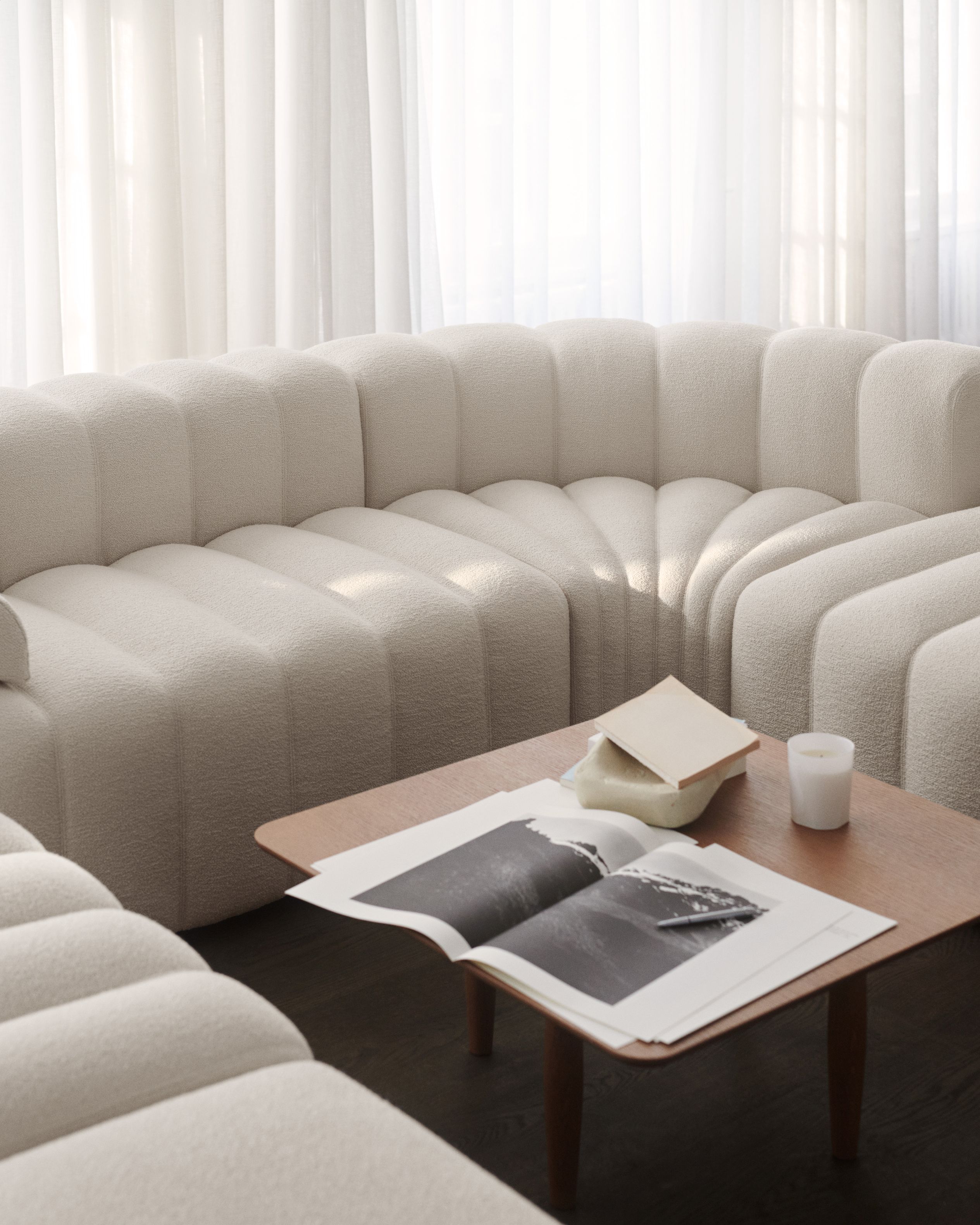 Oku Couchtisch Eiche schwarz von Norr11 im Wohnzimmer mit Sofa, Buch und Kerze.