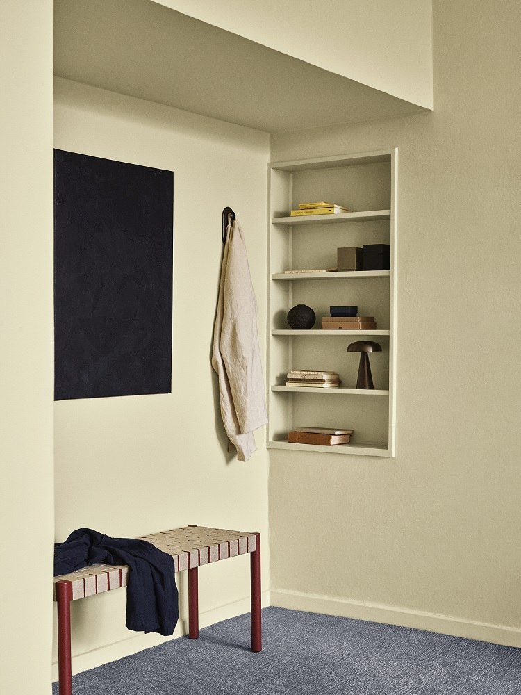 AndTradition Betty Bank TK4/TK5: Moderne Sitzbank mit Textilgewebe und roten Beinen im Flur.