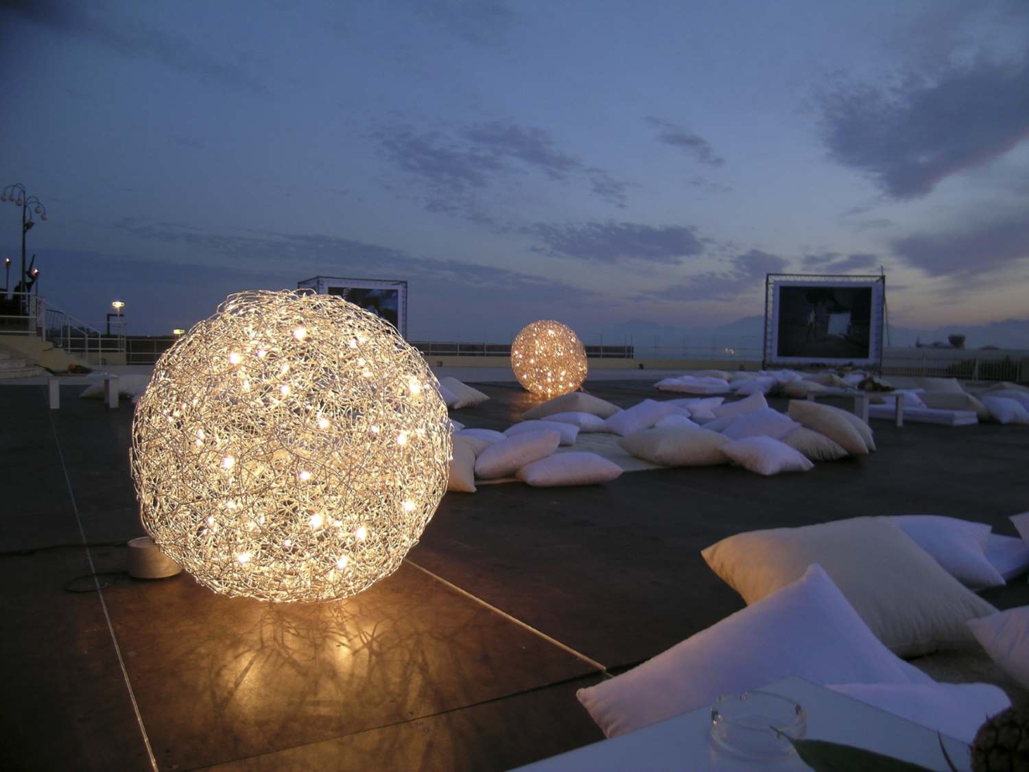 Fil de Fer Bodenleuchte: Runde, leuchtende Outdoor-Lampe von Catellani & Smith auf einer Dachterrasse.