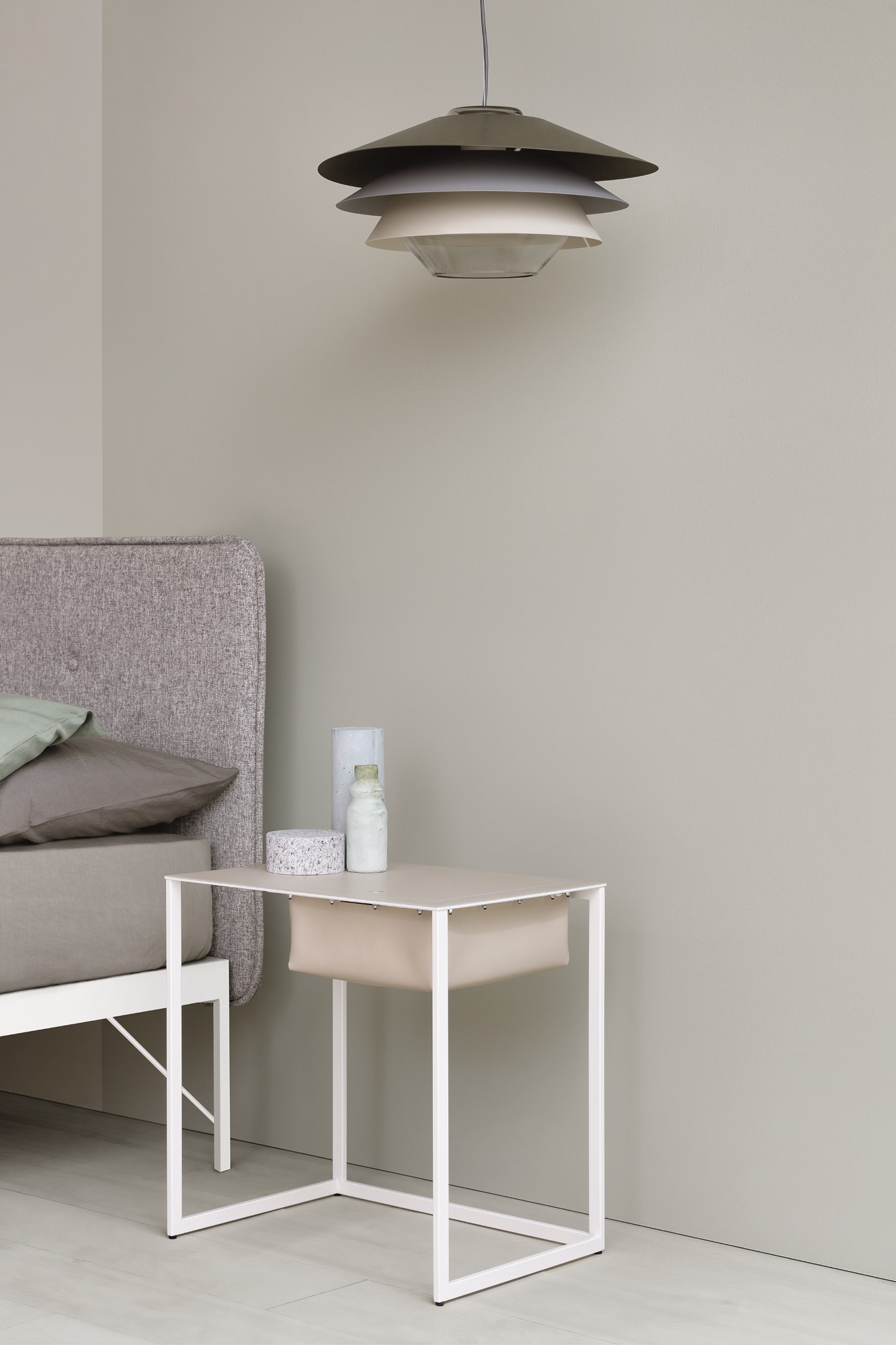 Taschino Nachttisch von Zanotta in Beige mit weißem Metallgestell und Stoffablage neben Bett.
