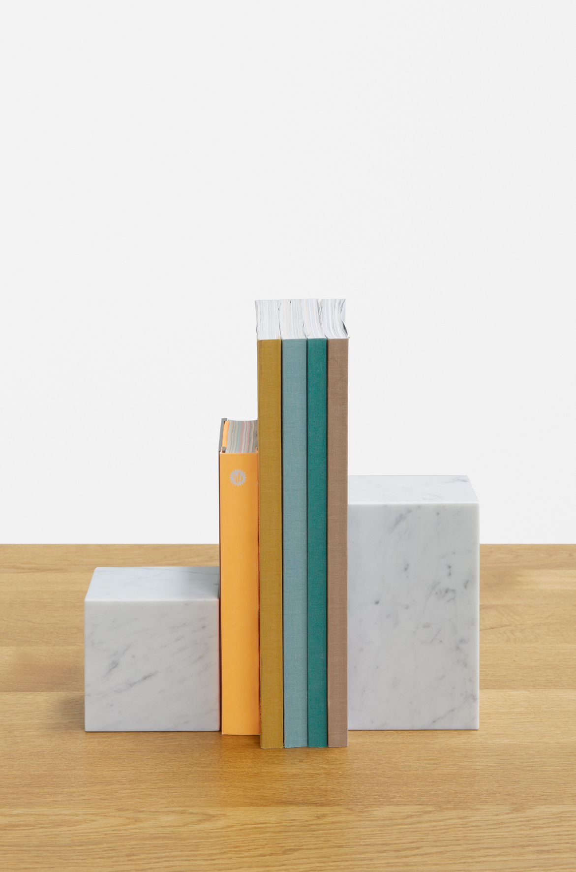 Weiße AC11 Stop Buchstütze von e15 aus Marmor hält farbige Bücher auf einem Holztisch.